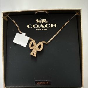 Coach gold colored bow necklace — new